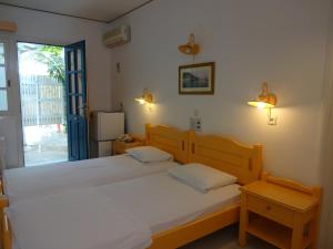 毕达哥利翁雷门佐一室公寓酒店的带窗户的客房内设有两张单人床。
