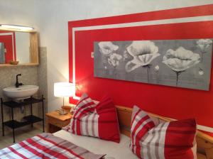 沃尔特湖畔佩莎赫卡拉克铃公寓的一间卧室设有红色墙壁、水槽和一张床