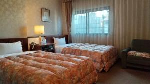 佐世保利奥广场酒店的酒店客房带两张床、椅子和窗户