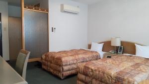 佐世保利奥广场酒店的酒店客房带两张床和一张搁脚凳