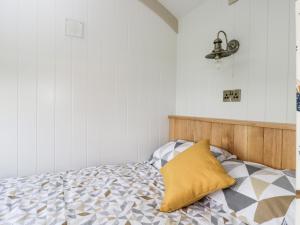 法灵登Waylands的一间卧室配有一张黄色枕头的床