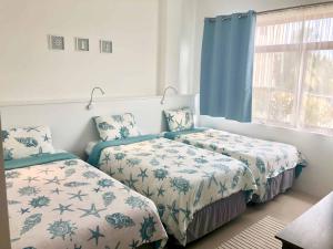 比亚米尔港Flip Flop House的一间卧室设有两张床和窗户。