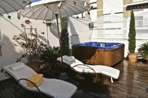 塞维利亚塞维利亚国王寝宫酒店的庭院设有热水浴池、2把椅子和遮阳伞。