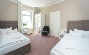 奥斯赛拜-屈隆斯博恩斯特兰科布公寓的一间卧室设有两张床、一把椅子和一个窗户。