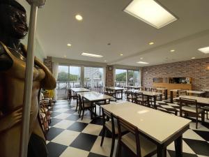 白滨Marina Hotel Kaikuu的中间设有餐桌和雕像的餐厅