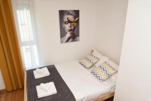索科矿泉村Millenium apartment的一间小卧室,配有带2条白色毛巾的床