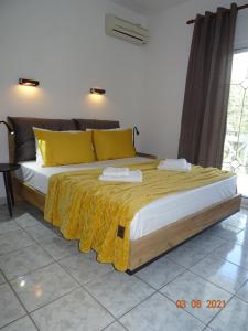 萨索斯Studios Anais - Thasos的一间卧室配有一张带黄色枕头的大床