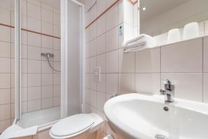 萨斯尼茨Hotel Mukran的一间带水槽、卫生间和淋浴的浴室