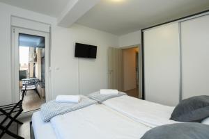 克拉多沃Apartman Klara的卧室配有一张床,墙上配有电视。