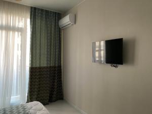 巴统Horizons Hotel Rooms的卧室配有壁挂式平面电视。