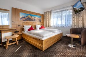 贝希特斯加登丹尼格勒亨安培酒店的酒店客房设有一张大床和一张书桌。