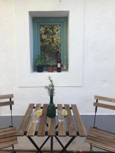 MonoszlóKáli Kerted Vendégházak Karolin néni háza的一张木桌,配有一瓶葡萄酒和玻璃杯