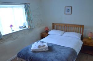 DunsfordThe Royal Oak Inn的一间卧室配有带毛巾的床