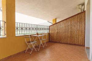 弗卢米尼马焦雷Anima Hotel Sardinia的客房设有桌椅和阳台。