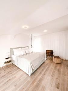 兰什克龙Penzion Jakub的一间铺有木地板的白色卧室,配有一张床