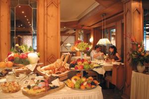 费斯恩洛特费西巴桑纳贝切尔酒店的一群坐在桌子上的人,他们拿着水果和蔬菜