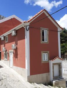塞尔唐Hostel Sertã的红白色房子,有车道
