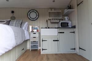彻奇斯特雷顿Hilltop Hut的一间卧室配有一张床,厨房配有微波炉