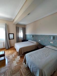 巴约讷罗姆铺拉丝酒店的一间酒店客房,房间内设有两张床