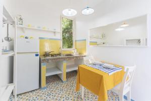 普罗奇达Le Querce的一间小厨房,配有黄色桌子、黄色桌子和黄色椅子