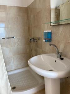 波罗斯Hotel Galini的浴室配有水槽、淋浴和浴缸。