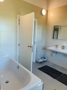 霍尔斯贝克Landlord的白色的浴室设有浴缸和水槽。