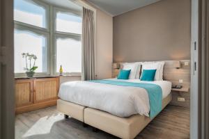 布鲁日马拉博伊酒店的一间卧室配有一张带蓝色枕头的大床