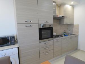 马尔萨斯卡拉Aquamarine Sea Front Apartments - Second Floor的厨房配有不锈钢橱柜和微波炉