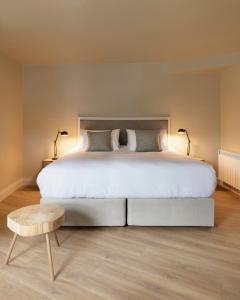 肯梅尔Lagom Restaurant & Townhouse的卧室配有一张白色大床和木凳