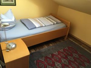 胡苏姆Treibweg 41的一间小卧室,配有一张带灯和地毯的床