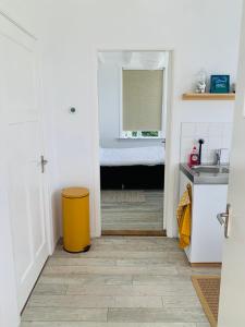 奥德多普Studio49的浴室设有黄色垃圾桶和水槽