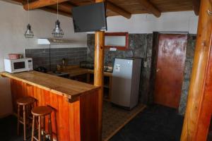 圣地亚哥Lodge en Farellones的厨房配有冰箱和带凳子的台面