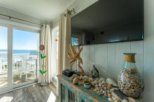 默特尔比奇Charming Ocean-view Condo at Ocean Pier 3的一间设有一张桌子、贝壳和花瓶的房间