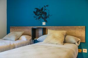 坎德莱达Hostal La Pastora的一间卧室设有两张床和蓝色的墙壁