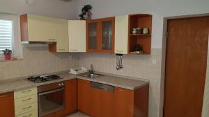 赫瓦尔博森洛索公寓的厨房配有木制橱柜、水槽和炉灶。