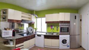 圣地亚哥－德孔波斯特拉CARMELA的厨房配有白色橱柜和绿色墙壁