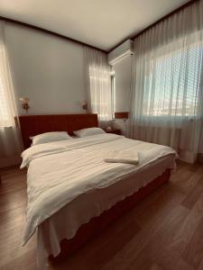 斯特鲁加Hotel Ambient - Struga的一间卧室配有一张带白色床单的大床
