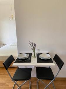 卡萨马西马Bed and Breakfast Gaia的一张带两把椅子和盘子的白色餐桌