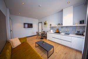 萨兰达Apart-Hotel Lili2的带沙发的客厅和厨房