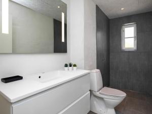 洛肯6 person holiday home in L kken的浴室配有白色水槽和卫生间。