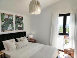 GaricaLazy 8 Villa的卧室配有白色的床和大窗户