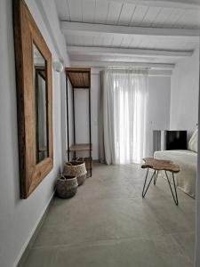 米克诺斯城Sofos Suites Mykonos的一间卧室配有一张床、一张桌子和一面镜子