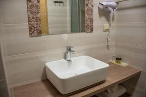 卡什泰拉Benjamin Hotel的浴室设有白色水槽和镜子