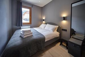 索尔德乌Soldeu Gall de Bosc Luxury Apartment apt Bon aire的一间卧室,卧室里配有一张床,上面有一堆毛巾