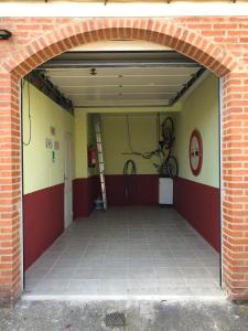 UruñuelaCHALET ADOSADO CON GARAGE Y TERRENO的车库设有开放式门,墙上挂有自行车