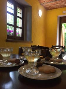 萨塞洛Rifugio Casa Ressia的一张桌子,上面放着三杯酒和饼干