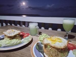 LagudriYohanes Guest House Sorake Surf-Nias的一张桌子,上面放着两盘食物和饮料