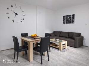 索科矿泉村Apartman Ljiljan的客厅配有桌子、沙发和时钟