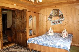 亚布卢尼齐亚У Василини的木制客房内的一间卧室,配有一张床