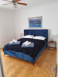 迪斯诺Apartments Perina的一间卧室配有蓝色的床和2条毛巾